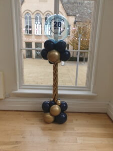 A balloons stand in front of a window at NTU
